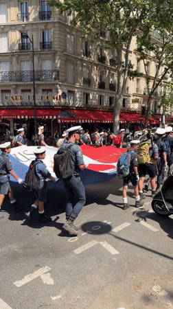 Uniformed youth procession with flags marches through central Paris