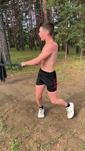 Group resistance band training at a lakeside outdoor gym in Krasnoturansk