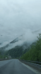 Vehicle travels through cloudy mountain forest near Chvizhepse, Russia