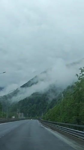 Vehicle travels through cloudy mountain forest near Chvizhepse, Russia