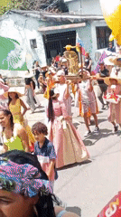 Traditional parade with flags and religious statue in Tinaquillo