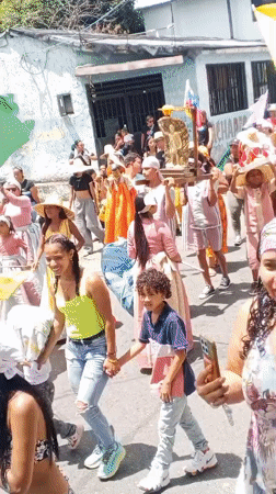 Traditional parade with flags and religious statue in Tinaquillo
