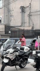 Man holds rooster near LAPD motorcycles in Los Angeles