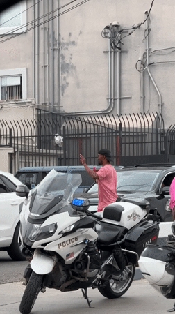 Man holds rooster near LAPD motorcycles in Los Angeles