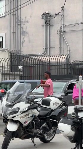 Man holds rooster near LAPD motorcycles in Los Angeles