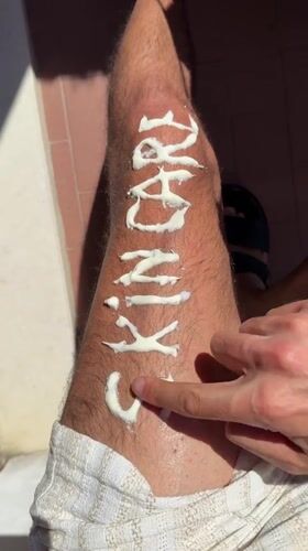 Person writes skincare messages on leg with cream in Milan