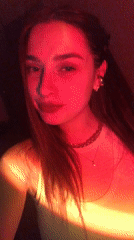 Woman records selfie videos in red lighting in Noviy