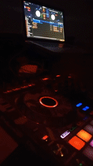 DJ performs with illuminated Pioneer controller at dimly lit venue