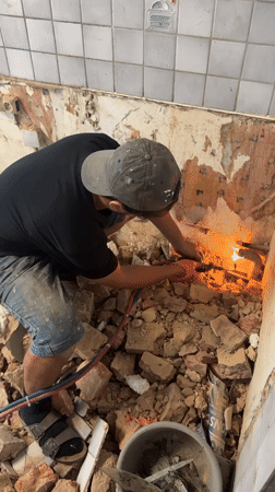 Torch cutting through pipes at a rubble-filled Roubaix site