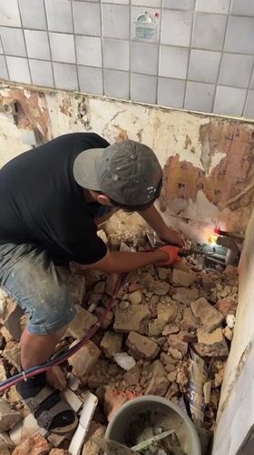Torch cutting through pipes at a rubble-filled Roubaix site
