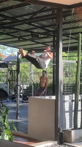 Man performs advanced calisthenics at outdoor gym in Mengwi