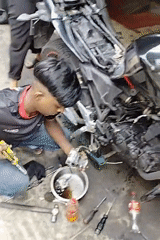 Motorcycle carburetor work at a Dhaka repair spot