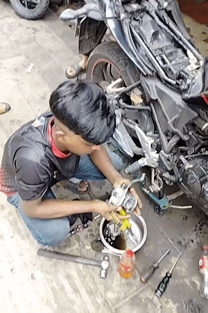 Motorcycle carburetor work at a Dhaka repair spot