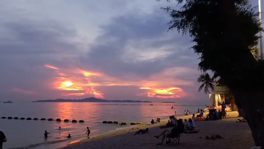 Sunset draws beachgoers to Pattaya shore amid dramatic clouds