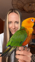 Woman sings with colorful parrot companion