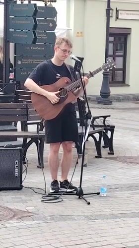 Street musician performs in busy Minsk district amid cafe scene