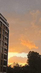 Urban sunset documented across apartment buildings and parking areas