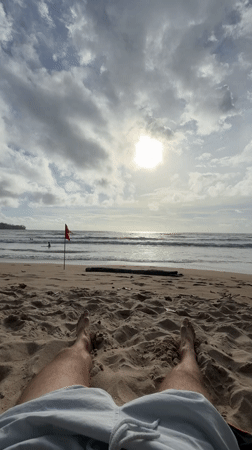 Beachgoer relaxes on sand at Kamala Beach, Thailand