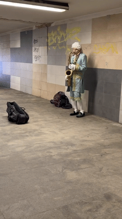 Costumed saxophonist performs in Riga tunnel amid local food displays