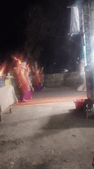 Traditional dancing and street vendors at a nighttime event in Ngebra