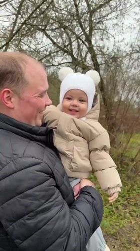 Man with baby, woman captured in outdoor Reshetnikovo scene