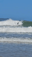 Surfer rides waves at Búzios beach on sunny afternoon