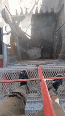 Standing over a rubble-filled chute at an Armenian demolition site