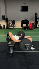 Woman performs barbell exercises at Mexican gym facility