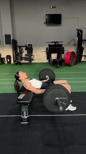 Woman performs barbell exercises at Mexican gym facility