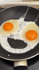 Fried eggs form smile shape while cooking in kitchen