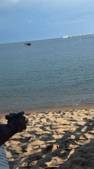 Person filmed on sunny Barcelona beach during afternoon