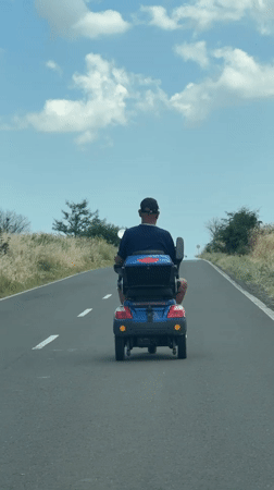 Mobility scooter rolling down a paved road in Krustina