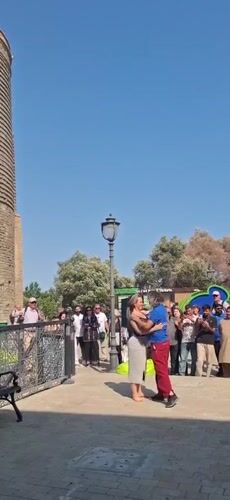 Live music and dancing near a historic tower in Baku
