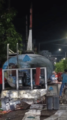 Nighttime street scenes show bustling Bengali urban commercial district