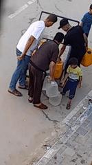 Carrying water by hand in Khan Yunis streets