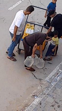 Carrying water by hand in Khan Yunis streets