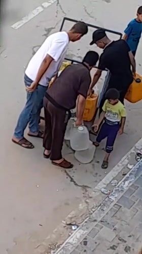 Carrying water by hand in Khan Yunis streets