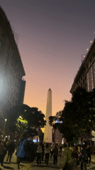 Evening crowds gather around Buenos Aires Obelisco monument