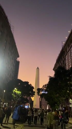 Evening crowds gather around Buenos Aires Obelisco monument