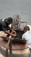 Two workers maintain rusted well in Lagos
