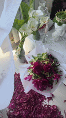 Person scatters magenta peony petals on floor in Vesyoloye