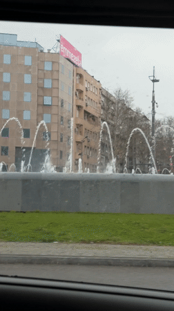 Rainy day fountain view captured from car in Belgrade