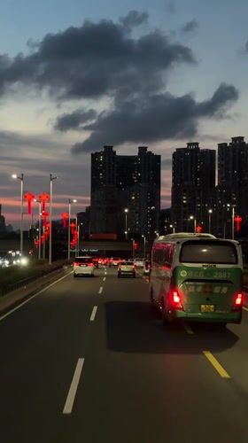 Evening traffic flows past red lanterns in Nanshan District