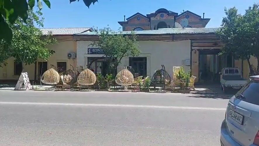 Rattan chairs lined up outside Samarkand building on sunny morning
