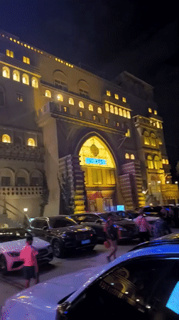 Ornate building with neon signage lit up at night in Ürümqi