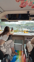 Tourist documents morning street scenes from Guangzhou tour bus
