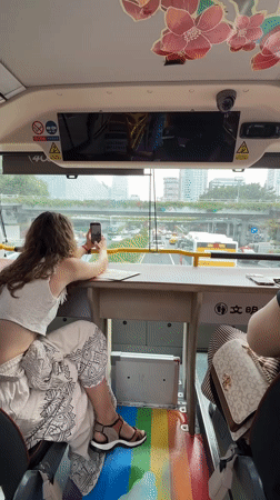 Tourist documents morning street scenes from Guangzhou tour bus