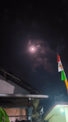 Hazy moonrise over Kutoarjo rooftops, with quiet nighttime scenes below