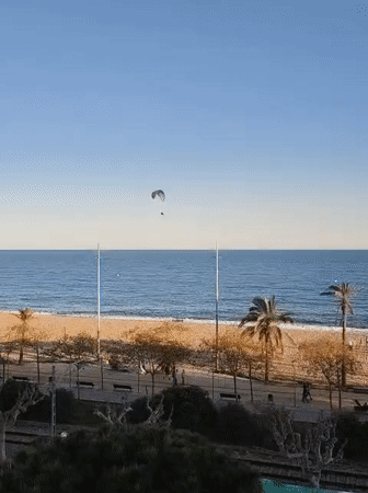 Paraglider soars over Mediterranean near Calella, Spain