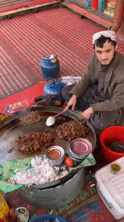 Street vendor cooks meat at outdoor market in Quetta